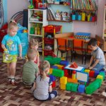 Preschoolers play with building a large construction set from parts