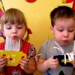 Boy and girl blowing on paper crafts
