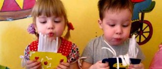 Мальчик и девочка дуют на поделки из бумаги